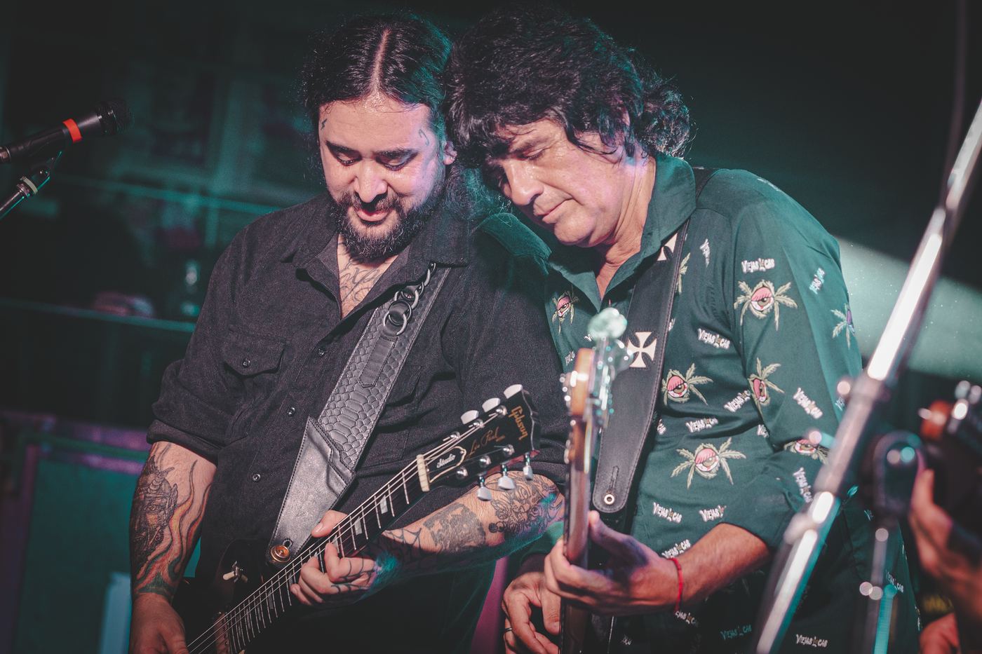 Dos guitarristas tocando juntos al borde del escenario